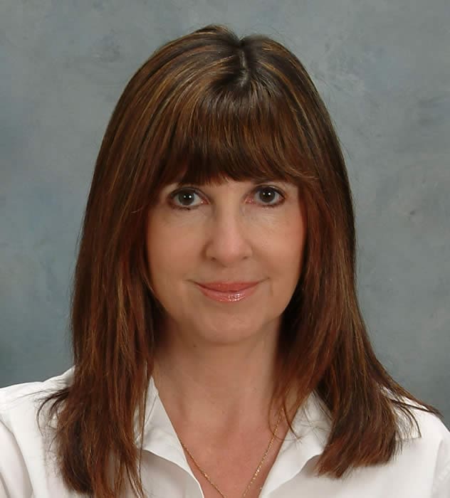 A woman with long brown hair and bangs.