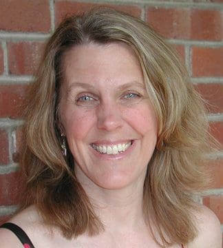 A woman with long hair smiles for the camera.