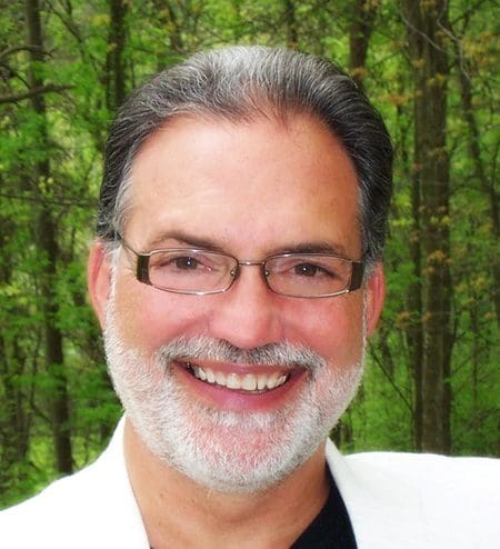 A man with glasses smiling for the camera.