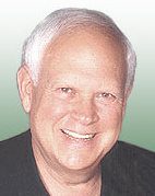 A man with white hair and wearing a black shirt.