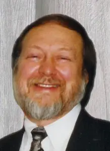 A man with long beard and mustache wearing a suit.