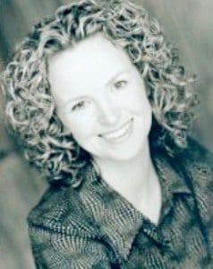 A woman with curly hair smiling for the camera.